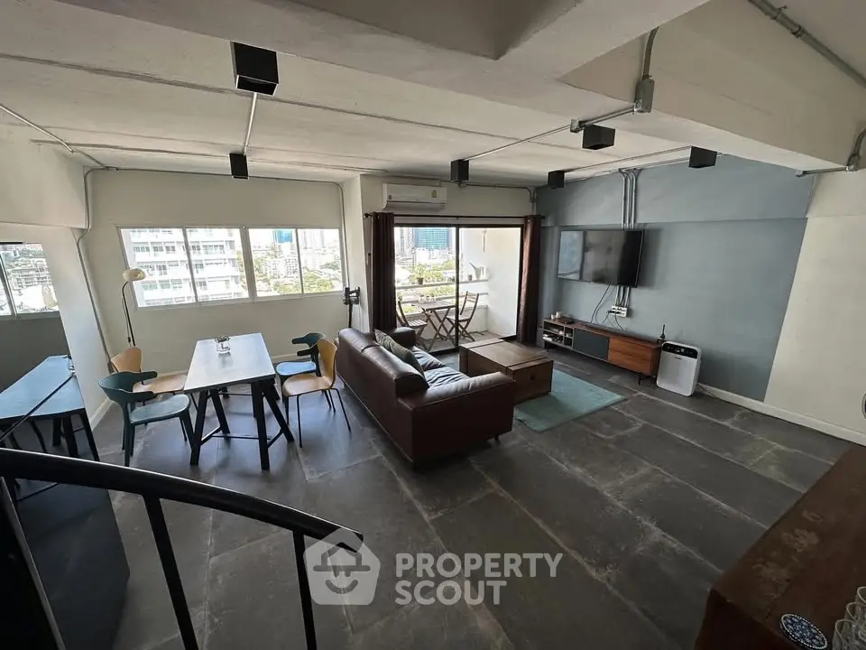 Spacious modern living room with city view, featuring stylish furniture and open layout.