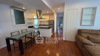 Spacious open-plan living room and kitchen with modern furnishings and wooden flooring.