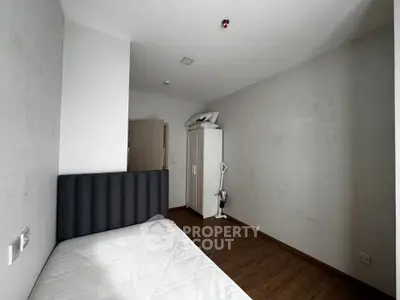 Minimalist bedroom with wooden flooring and modern furniture in a cozy apartment.