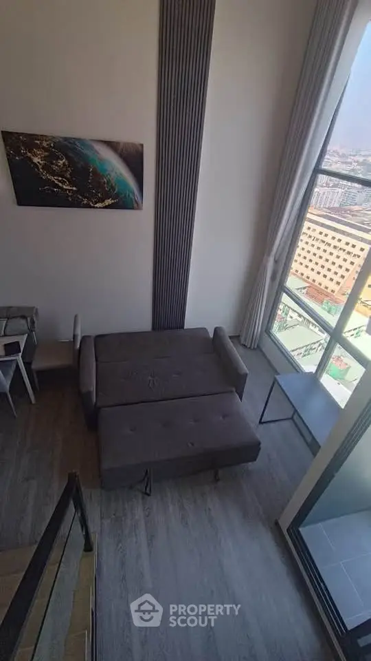 Modern loft apartment with high ceilings and large windows offering stunning city views.