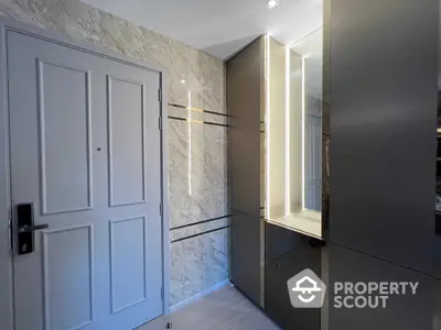 Sleek modern wardrobe with mirrored doors in a stylish bedroom, featuring elegant stone wall textures and a classic white door.