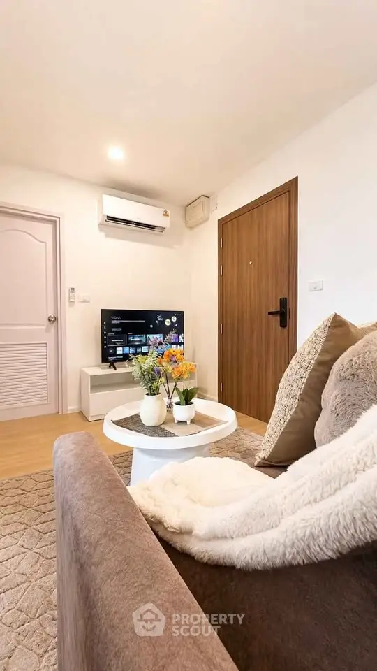 Cozy living room with modern decor, plush sofa, and flat-screen TV, perfect for relaxation.