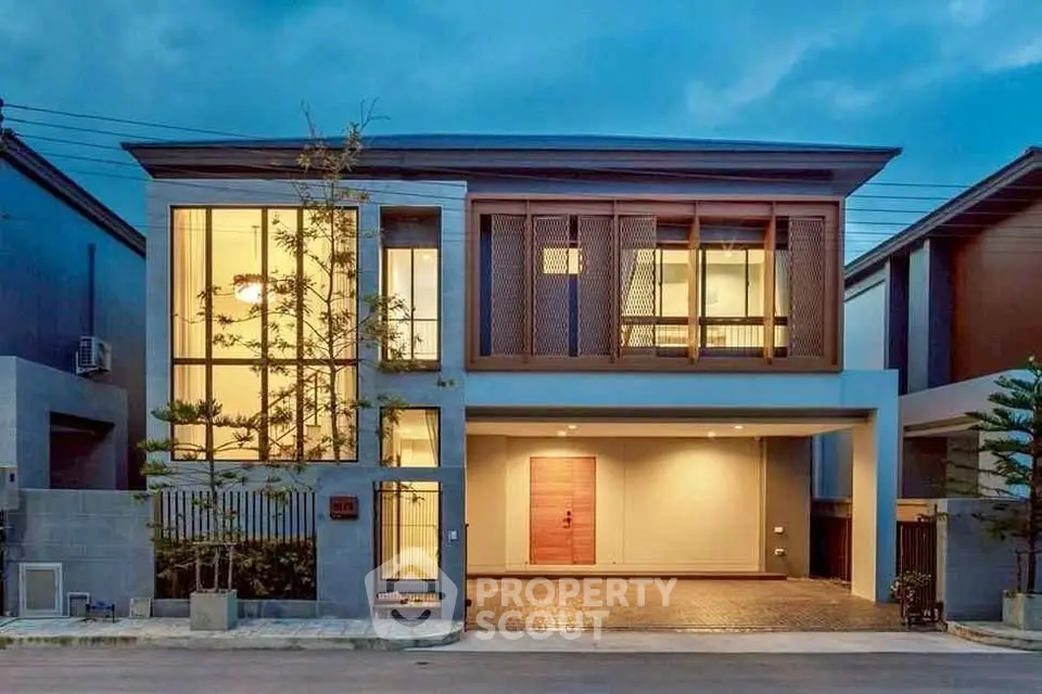Modern two-story house with large windows and stylish facade, showcasing contemporary architectural design.