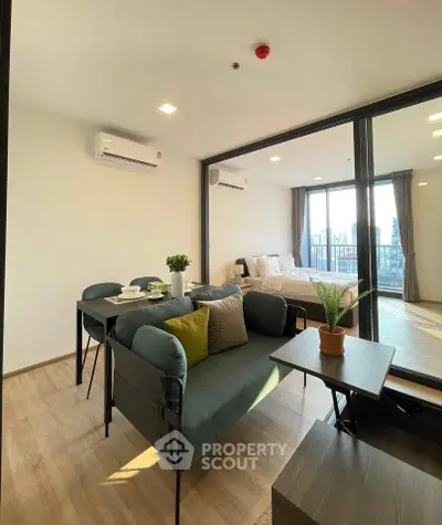 Modern apartment interior with open living and dining area, featuring stylish furniture and natural light.
