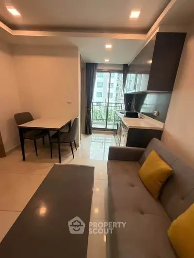 Modern living room with open kitchen and balcony view in a stylish apartment.