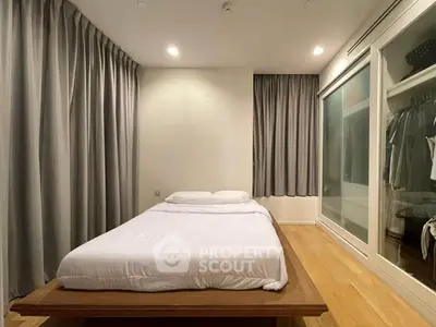 Spacious bedroom with modern design and ample closet space, featuring elegant curtains and wooden flooring.