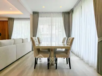 Elegant dining area with natural light and modern decor in a spacious living room.