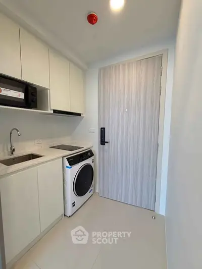 Modern compact kitchen with washing machine and sleek cabinetry