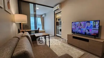 Modern living room with cozy sofa, TV, and dining area in stylish apartment.
