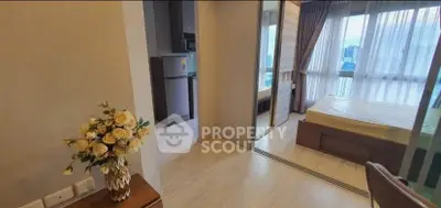 Modern apartment interior with bedroom and kitchen view, featuring elegant decor and natural light.