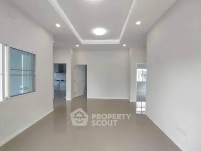 Spacious modern living room with sleek tile flooring and recessed lighting.