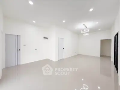 Spacious modern living room with sleek lighting and glossy tiled floors