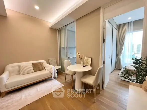 Modern living room with elegant decor and open view to bedroom, featuring cozy seating and stylish dining area.