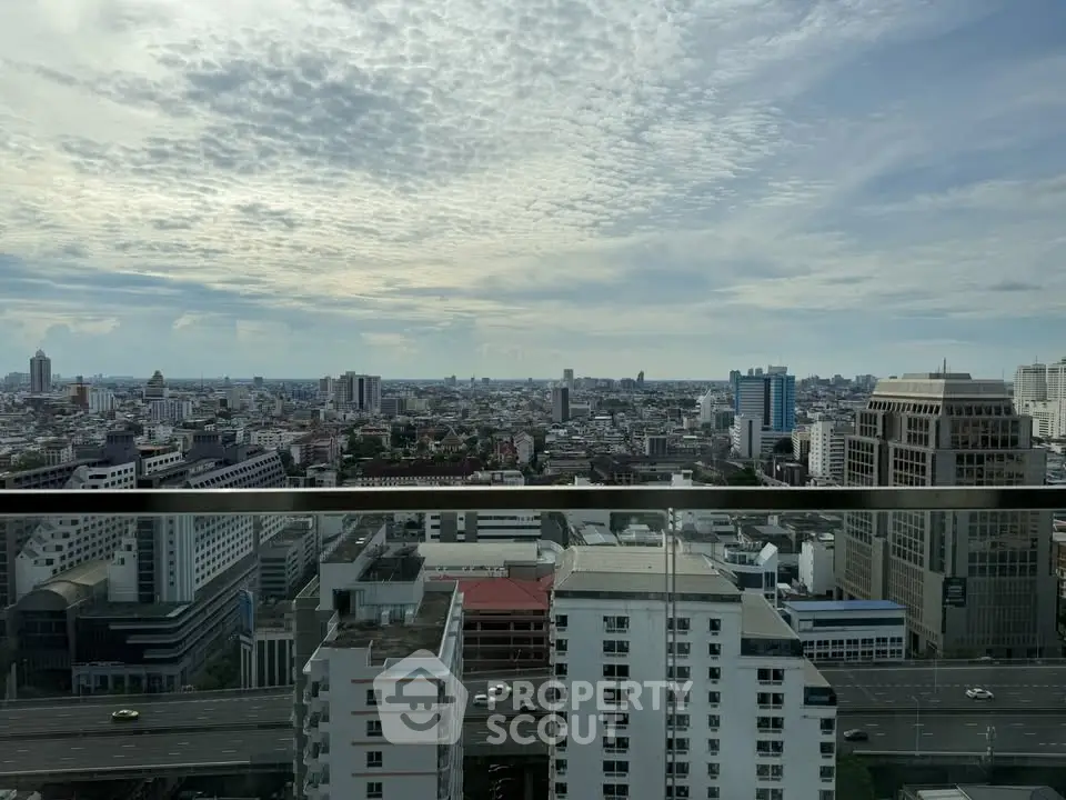 Stunning cityscape view from a high-rise balcony, showcasing urban skyline and expansive sky.