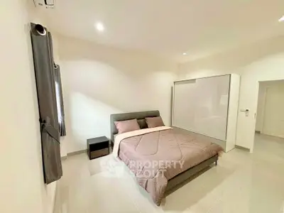 Spacious modern bedroom with sleek design and ample natural light.