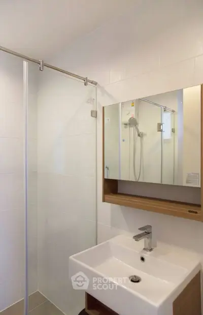 Modern bathroom with sleek shower and stylish sink in a contemporary apartment.