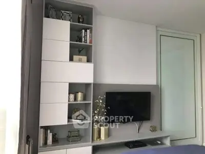 Modern living room with sleek shelving and flat-screen TV, perfect for stylish urban living.