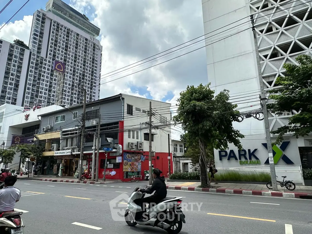 Street view of modern high-rise buildings and commercial area in vibrant city setting.