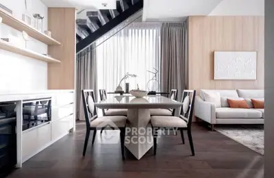 Modern living room with elegant dining area and stylish decor, featuring wooden floors and contemporary furniture.