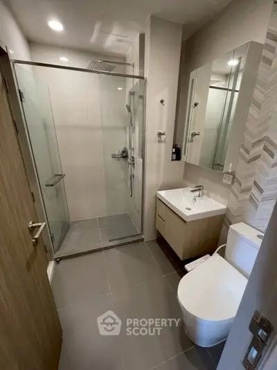 Modern bathroom with glass shower and sleek fixtures in a contemporary apartment.