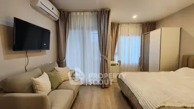 Cozy bedroom with modern decor, featuring a comfortable bed, sofa, and wall-mounted TV.