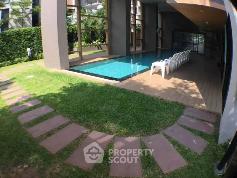 Luxurious residential pool area with modern design and lush greenery, perfect for relaxation and leisure.