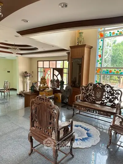 Elegant living room with ornate wooden furniture and stained glass windows