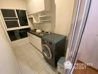 Modern laundry room with washing machine and sleek cabinetry