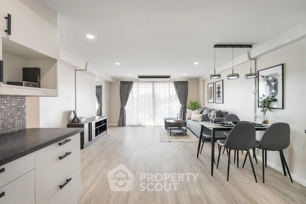 Spacious modern living room with open layout and elegant dining area, featuring stylish decor and natural light.