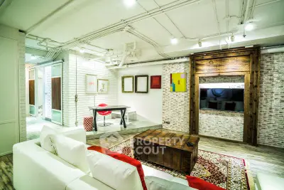 Stylish modern living room with exposed brick, cozy seating, and vibrant decor.