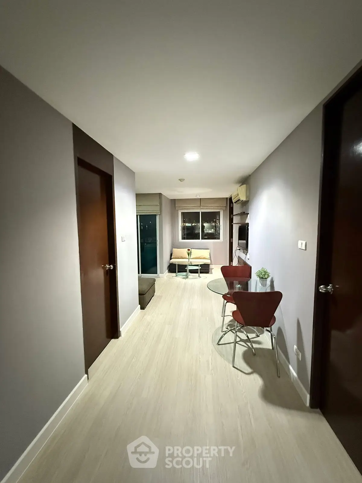 Modern apartment hallway leading to cozy living room with stylish furniture.