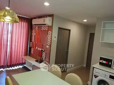 Modern living room with stylish decor, featuring a washing machine and microwave for convenience.