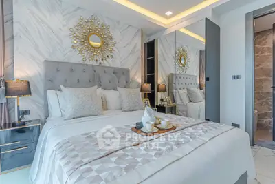 Luxurious bedroom with elegant decor and mirrored wardrobe in modern apartment.