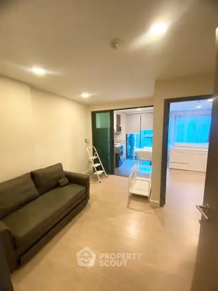 Cozy living room with modern sofa and open kitchen layout