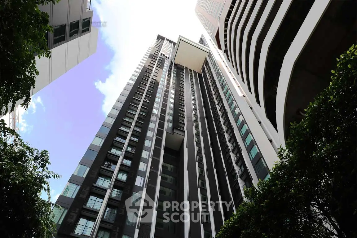 Stunning modern high-rise building with sleek architecture and lush greenery.
