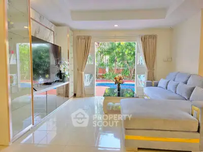 Spacious living room with pool view, elegant decor, and large sectional sofa in a modern home.