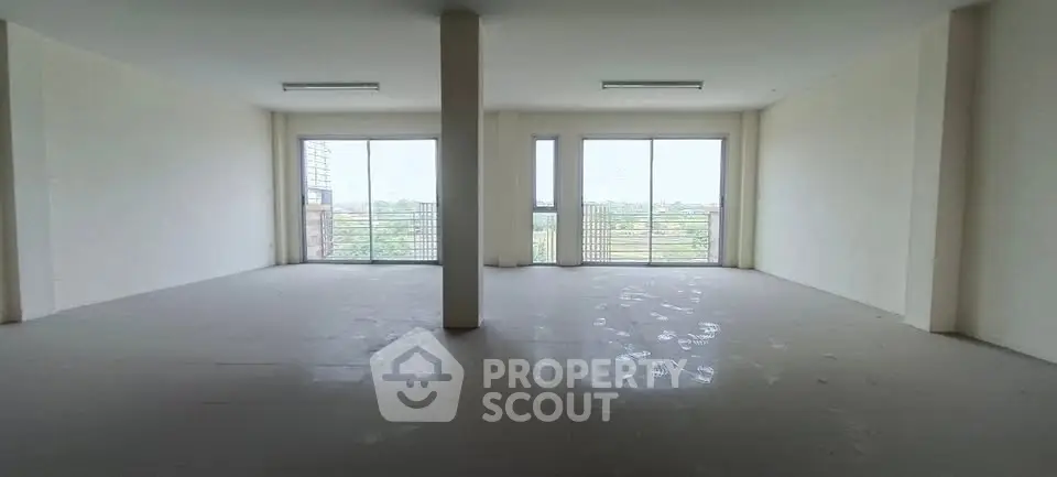 Spacious empty room with large windows and natural light, ideal for customization.
