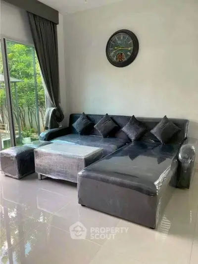 Modern living room with sleek black sofa and large window view