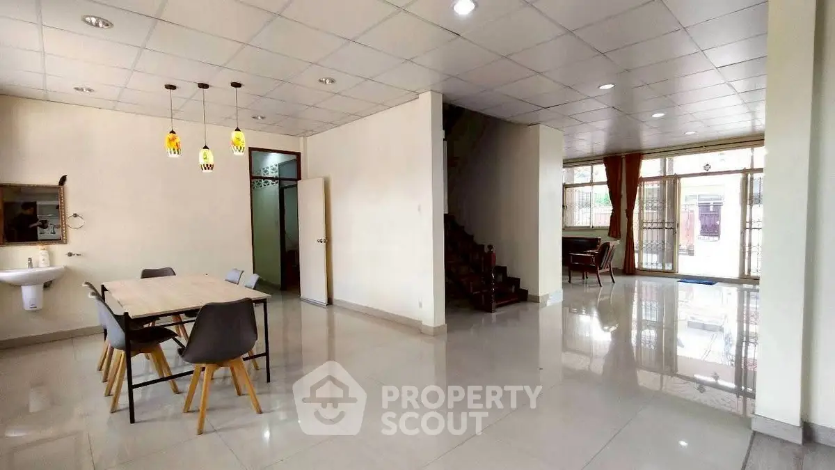 Spacious open-plan living area with dining space and staircase in modern home.