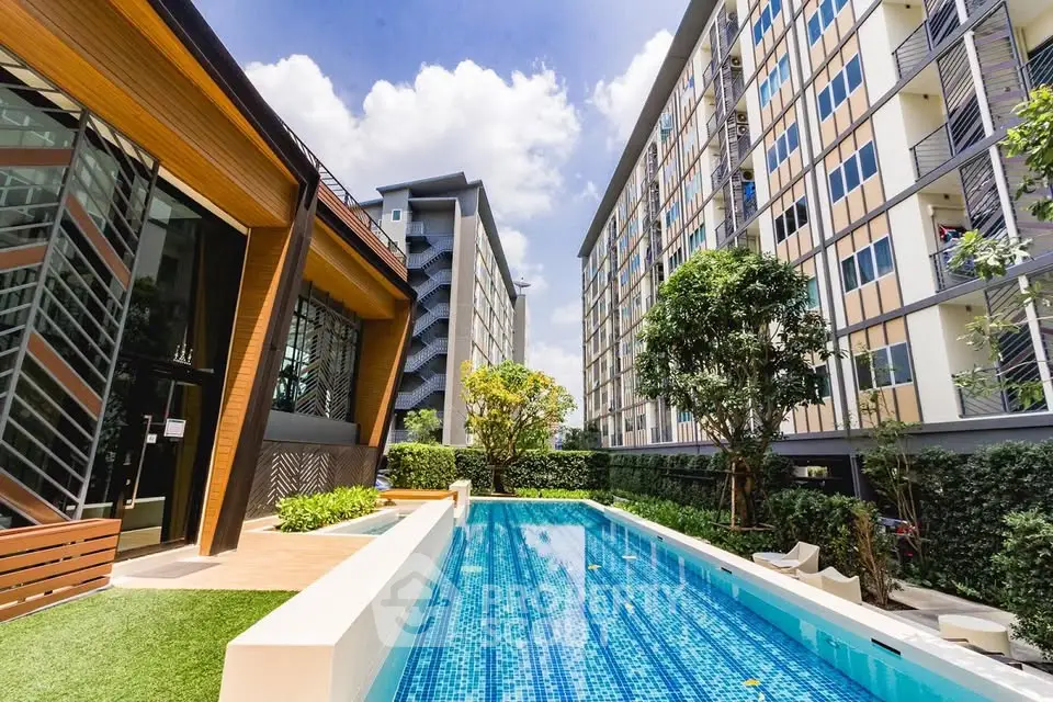 Modern apartment complex with a stunning outdoor pool and lush greenery.