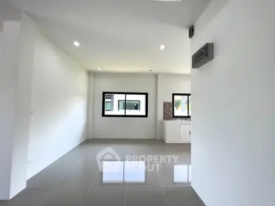 Spacious modern living room with large windows and glossy tile flooring