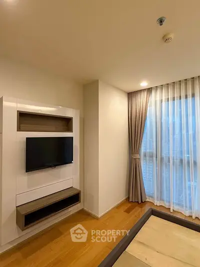 Modern living room with sleek TV unit and large window with city view