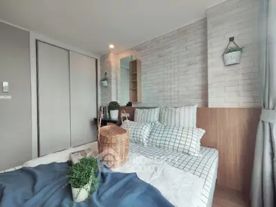 Cozy bedroom with modern decor and natural light, featuring stylish bedding and indoor plants.