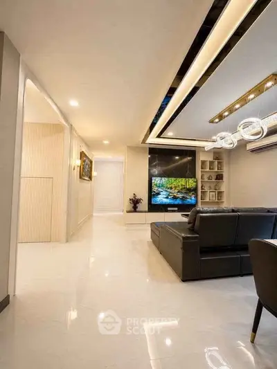 Luxurious modern living room with sleek design and large TV, perfect for relaxation and entertainment.