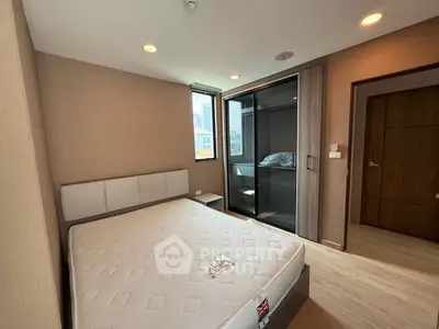 Modern bedroom with large window and built-in closet in urban apartment