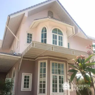 Elegant two-story house with large windows and gable roof