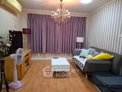 Charming living room with elegant chandelier and cozy sofa, perfect for relaxation.