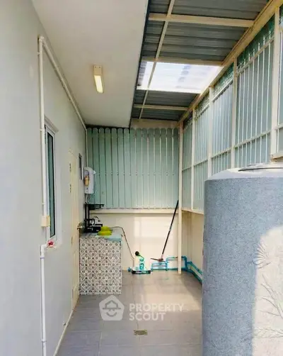 Spacious utility area with tiled flooring and ample natural light, perfect for laundry or storage needs.