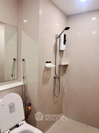 Modern bathroom with sleek shower and toilet in minimalist design.