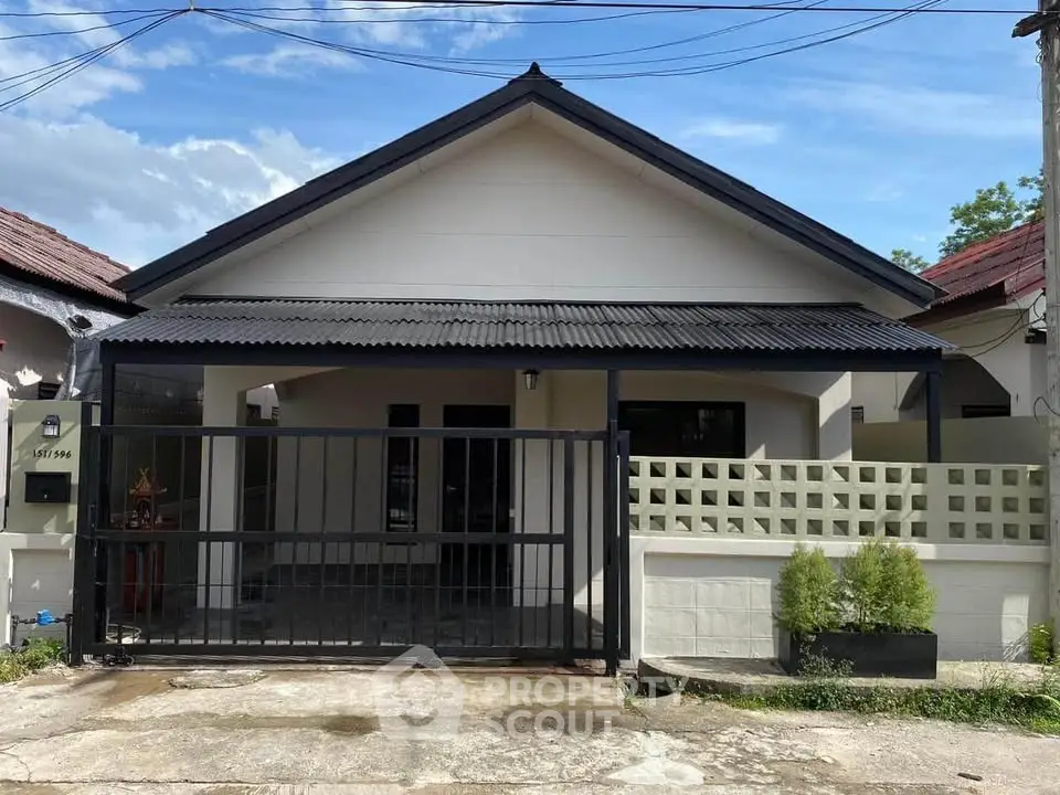 Charming single-story house with modern facade and gated entrance in a serene neighborhood.